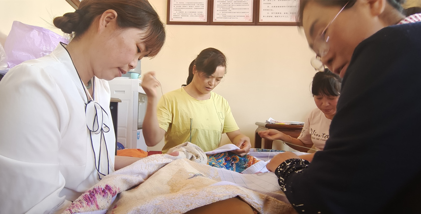 张菊花与绣女们正在赶制“百鸟朝凤”绣图。杨奇国供图